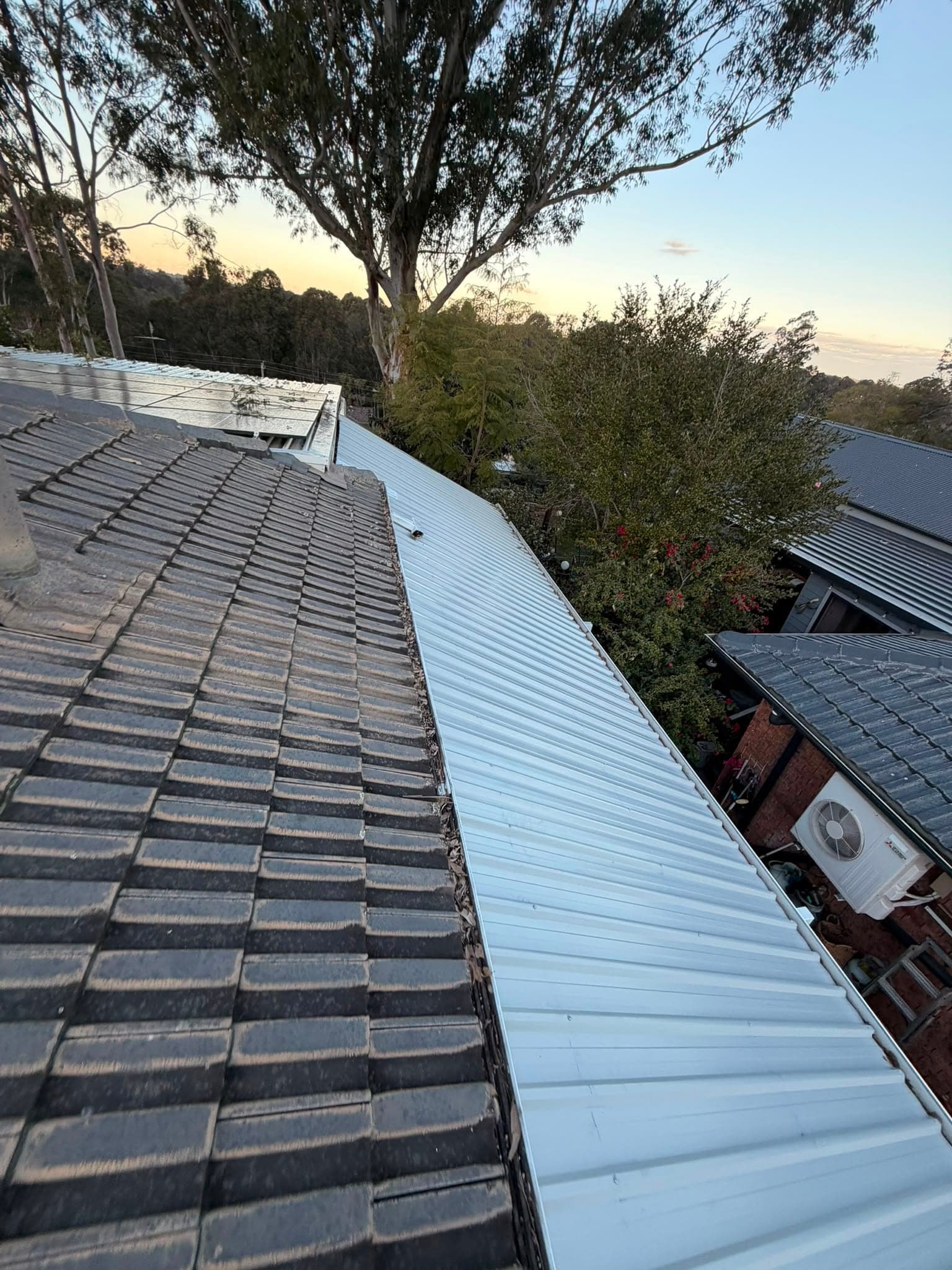 Colorbond and polycarbonate re-sheet Crown Roofers Emu Heights — before — original sheeting alongside the tiled main roof