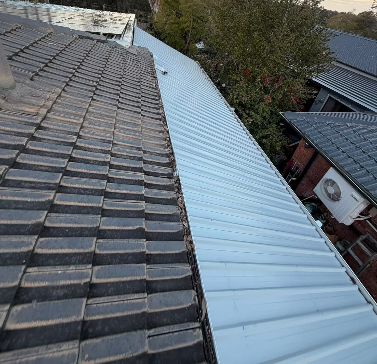 Colorbond and polycarbonate re-sheet Crown Roofers Emu Heights — before — original sheeting alongside the tiled main roof