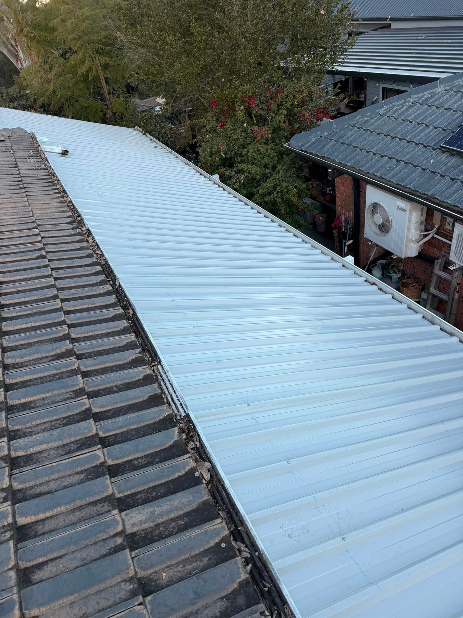 Colorbond and polycarbonate re-sheet Crown Roofers Emu Heights — new sheeting running clean into the gutter line