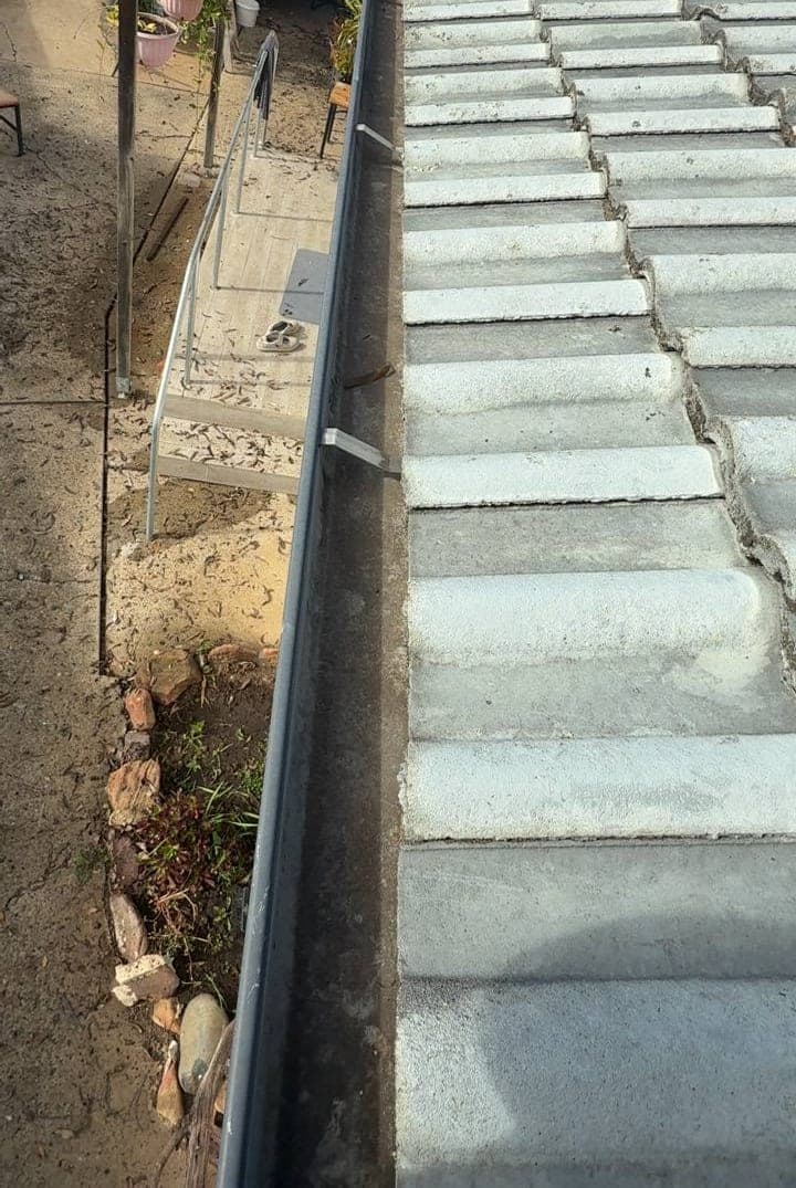 Residential gutter cleaning — Crown Roofers project Emerton Western Sydney — gutter-line wide angle showing debris extent