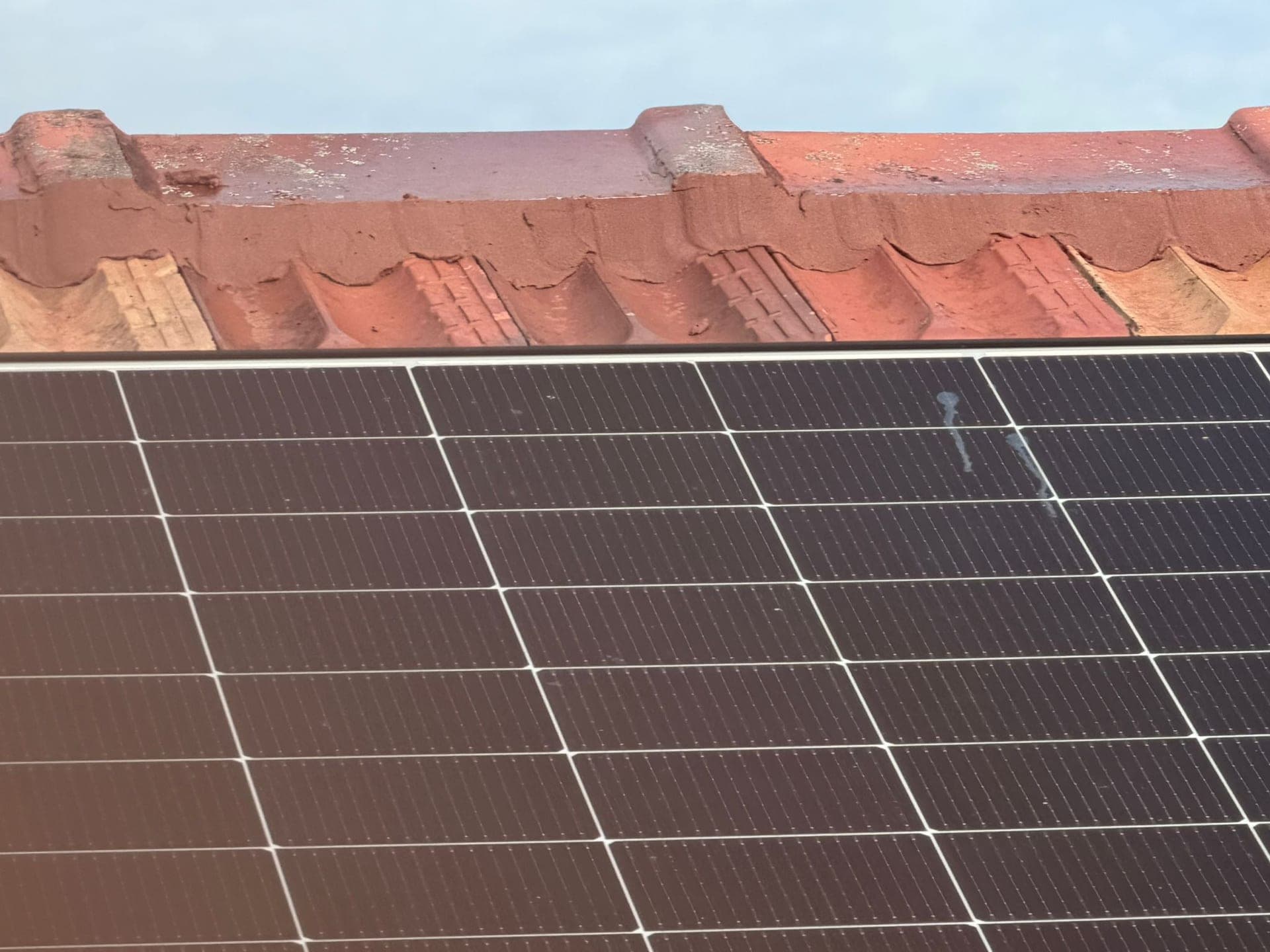 Aged terracotta tile roof with solar panels — Crown Roofers tile restoration project Epping North Shore Sydney — photo 2