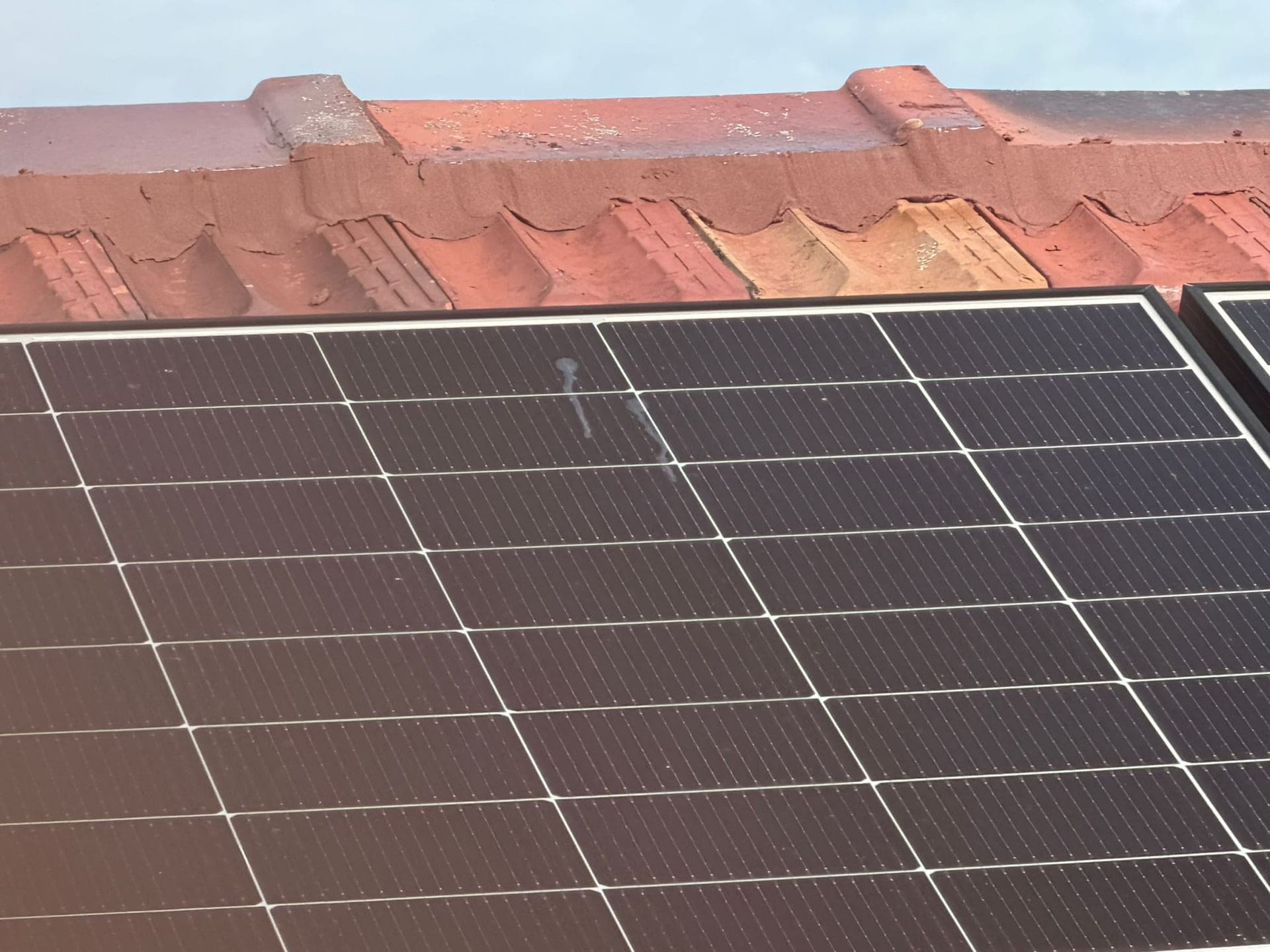 Aged terracotta tile roof with solar panels — Crown Roofers tile restoration project Epping North Shore Sydney — photo 3
