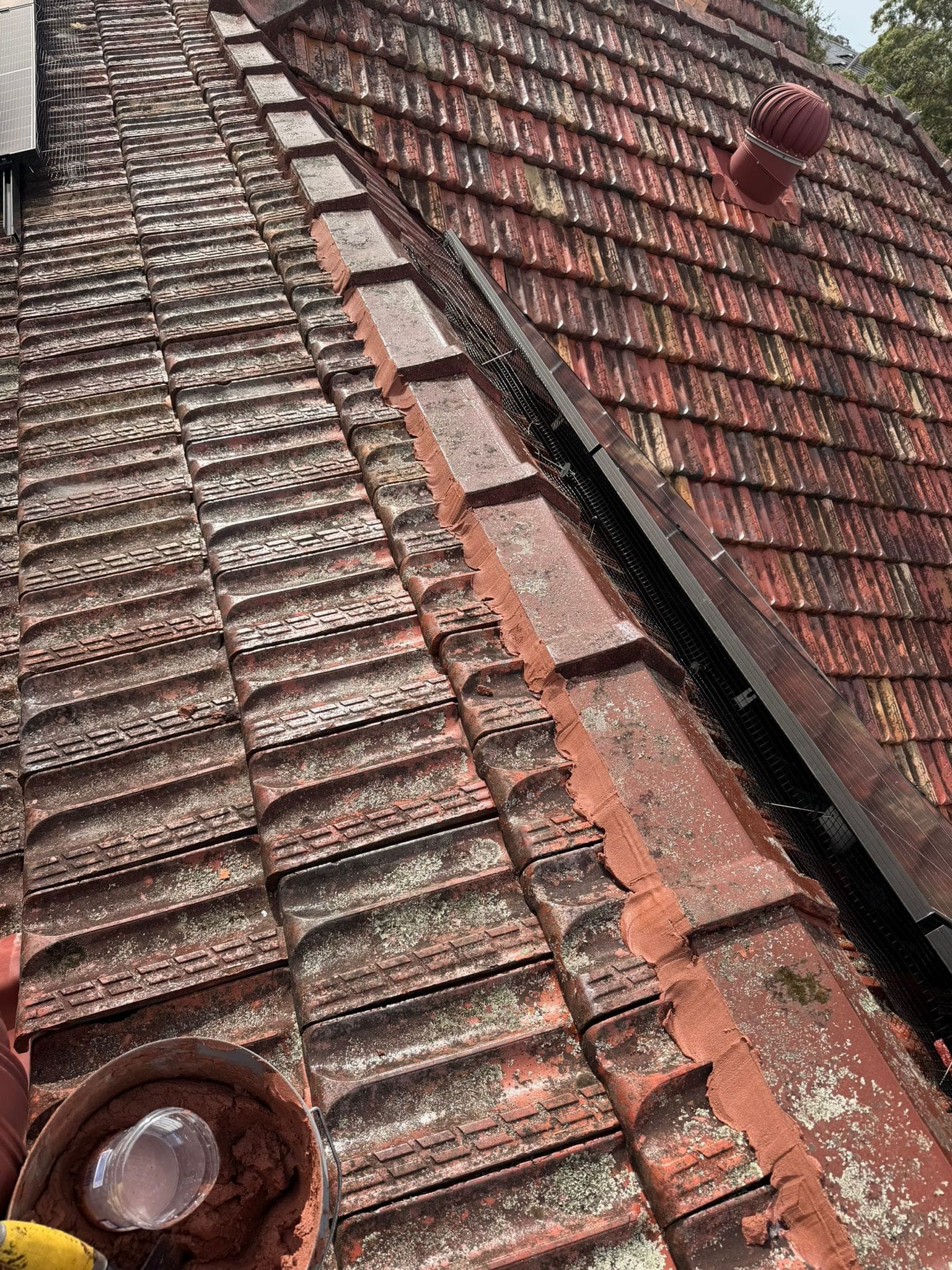 Aged terracotta tile roof with solar panels — Crown Roofers tile restoration project Epping North Shore Sydney — photo 16