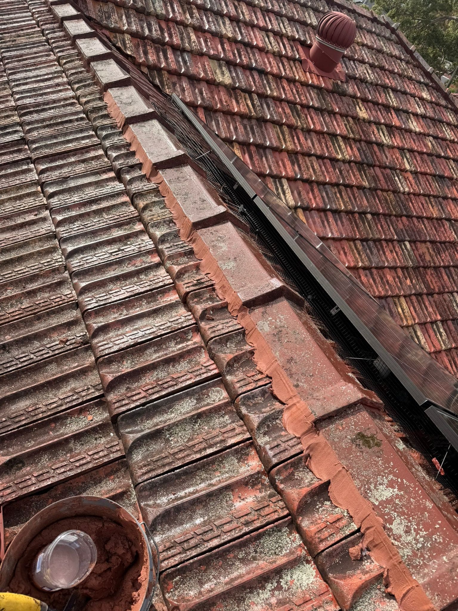 Aged terracotta tile roof with solar panels — Crown Roofers tile restoration project Epping North Shore Sydney — photo 20