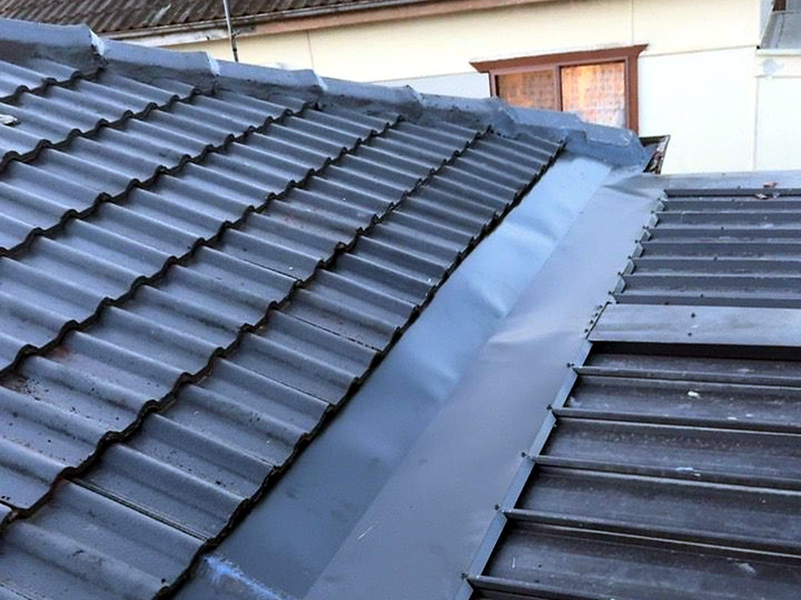 Transition flashing installed where a tile roof meets metal sheeting, Sydney