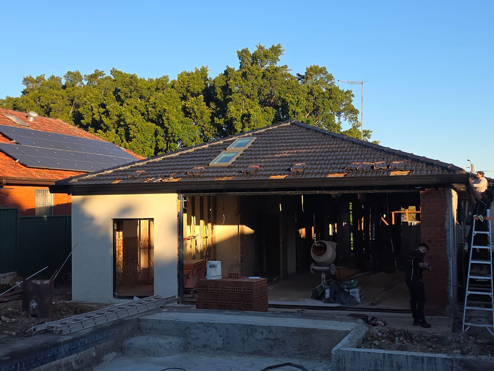 Tile roof restoration and new guttering Crown Roofers Kingsgrove — restored roof and ridge line viewed across the rear of the property