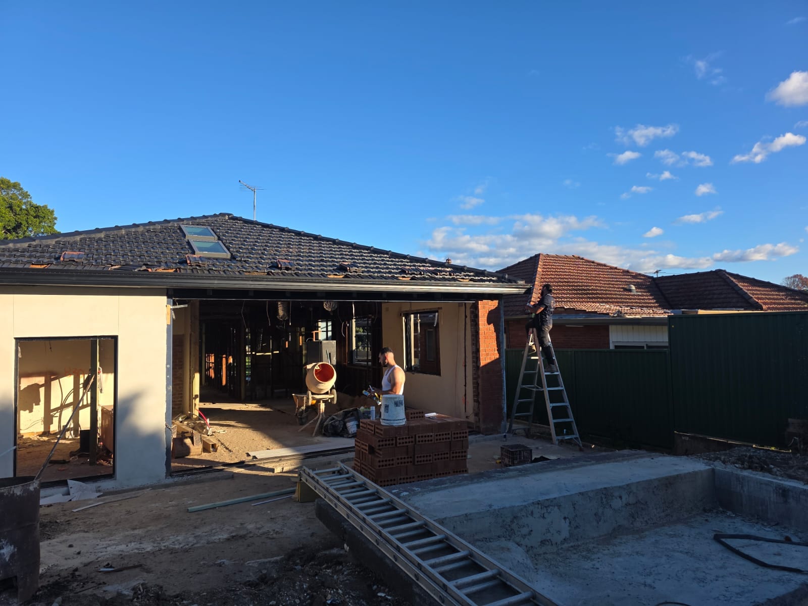 Tile roof restoration and new guttering Crown Roofers Kingsgrove — restored roofline and skylights over the renovated section